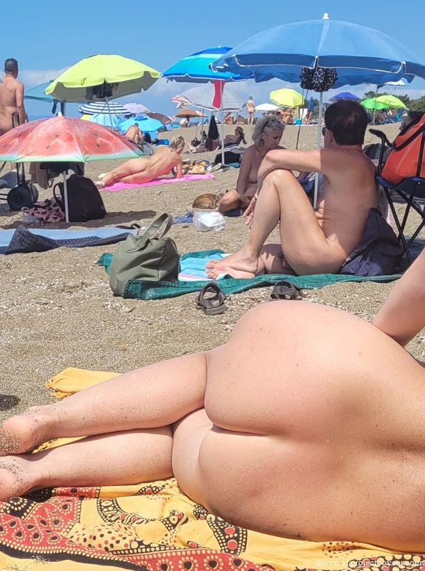 Ass and pussy on a nudist beach - image2